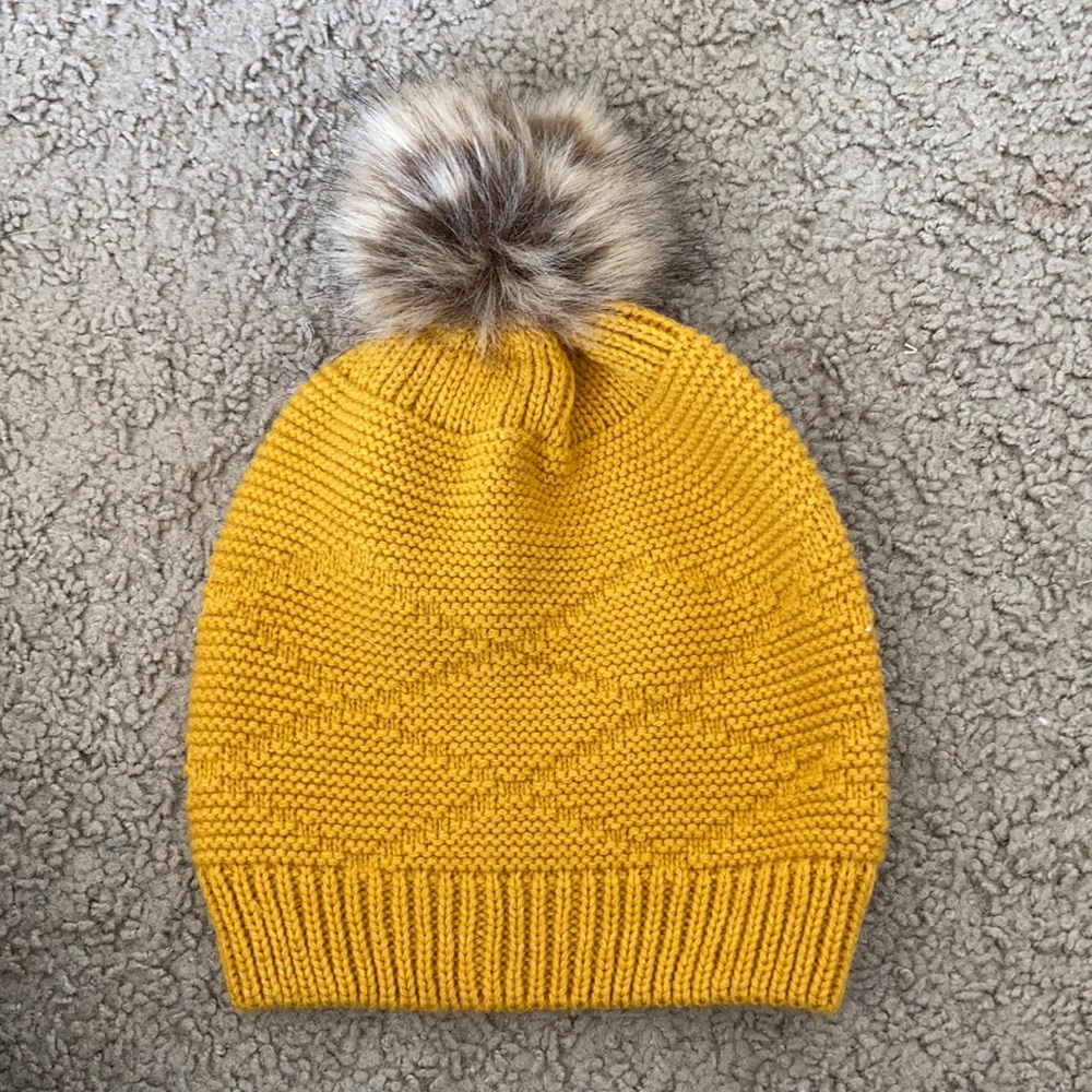 bright yellow hat with fur ball